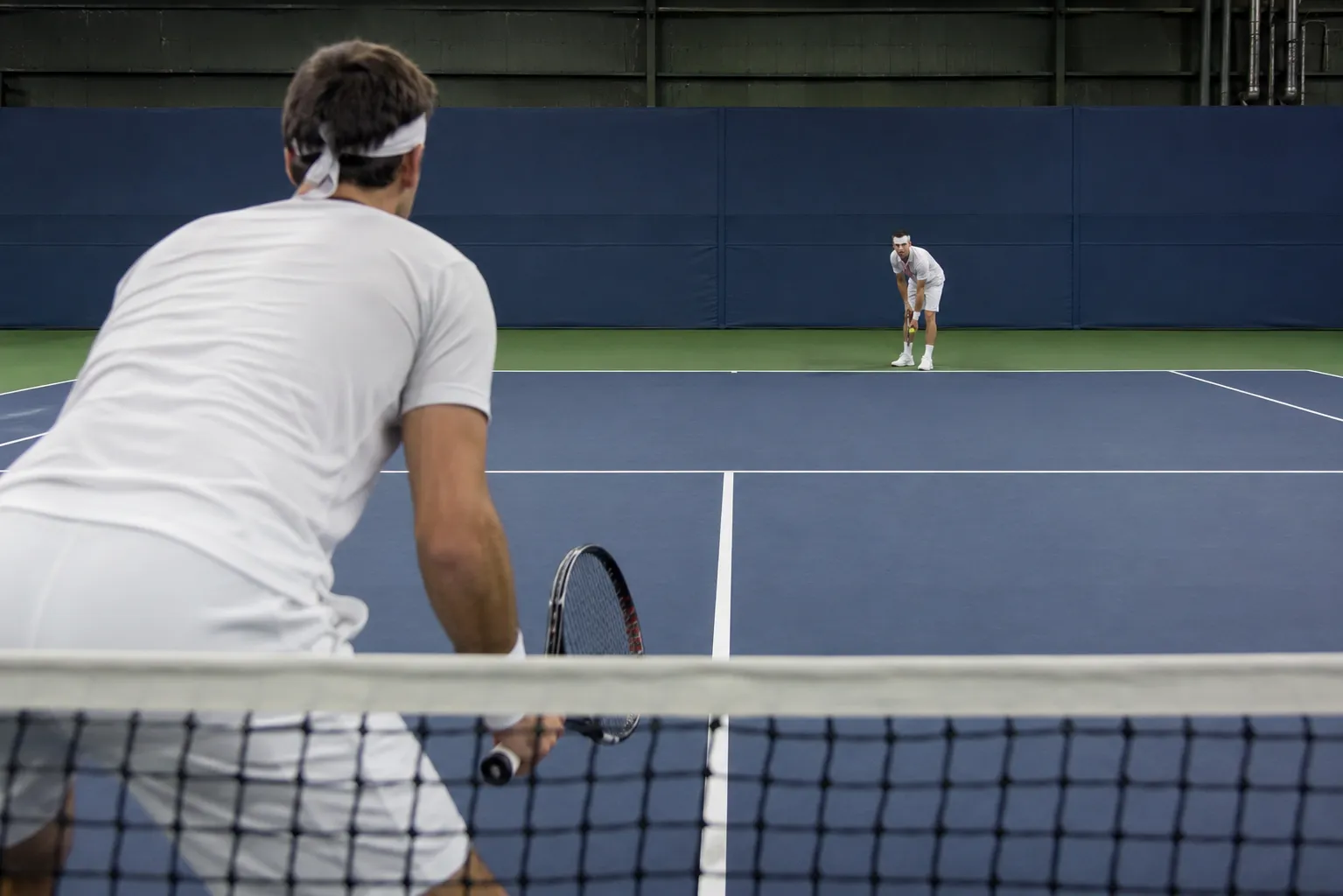 Two tennis players facing off across the net in a tight set